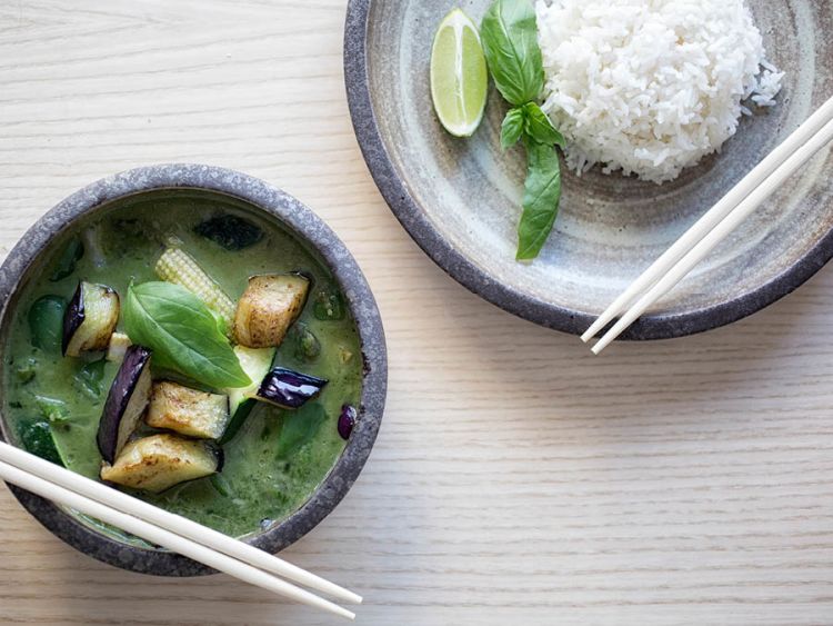 A bowl of curry and a plate of sticky rice